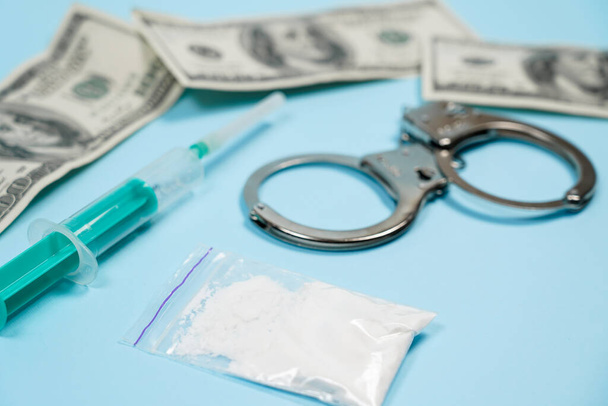 Мішок з наркотиками, долари США і наручники на столі. Концепція - покарання за зберігання наркотиків. Скопія спази, спеція для тексту.. - Фото, зображення