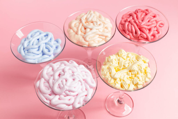  emulsiones multicolores para cremas cosméticas en vidrio sobre fondo rosa, de cerca - Foto, imagen