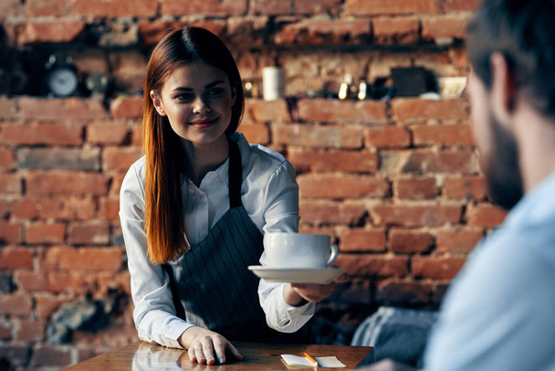 bella donna cameriere porta caffè servizio muro di mattoni - Foto, immagini