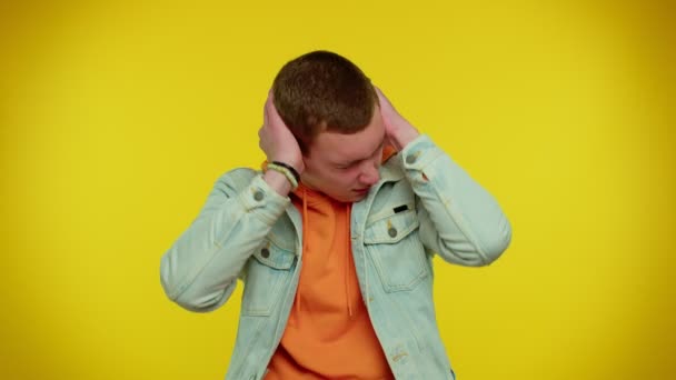 Απογοητευμένος εκνευρισμένος άντρας που καλύπτει αυτιά, αποφεύγοντας συμβουλές αγνοώντας δυσάρεστες φωνές - Πλάνα, βίντεο