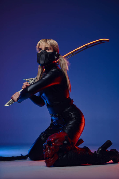Futuristic woman in tight clothes with sword - Foto, imagen