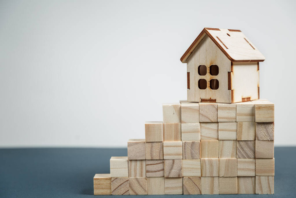 Koncepcja nieruchomości. Mały drewniany dom zabawka z kluczami z miejsca do kopiowania - Zdjęcie, obraz