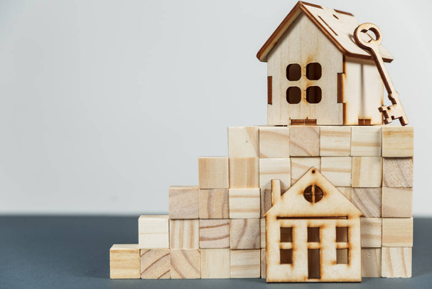 Conceito imobiliário. Pequena casa de madeira de brinquedo com chaves com espaço de cópia - Foto, Imagem