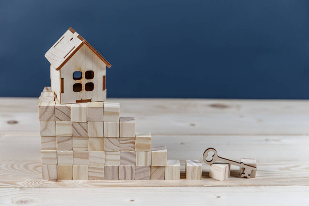 Immobilienkonzept. Kleines Spielzeug-Holzhaus mit Schlüsseln mit Kopierraum - Foto, Bild