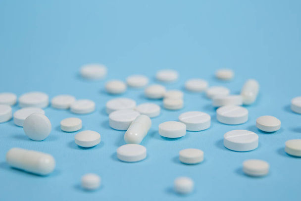 Λευκά ιατρικά χάπια σε μπλε φόντο. με αντίγραφο του χώρου - Φωτογραφία, εικόνα