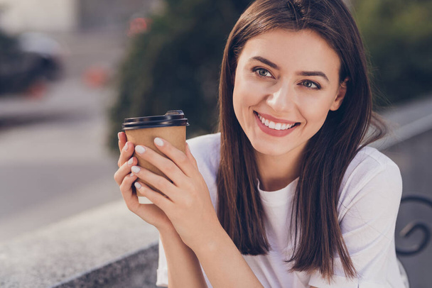 Photo portrait of happy girl drinking coffee outdoors wearing casual t-shirt - Foto, imagen