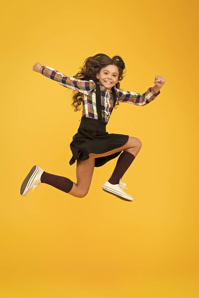 Be happy everyday. Happy child in midair yellow background. Having fun. Happy childhood. Raising happy kid. School holidays. International childrens day - Fotografie, Obrázek