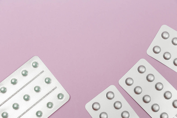 Pills in blister packs on a pink background with copy space for text or illustrations. - Fotó, kép