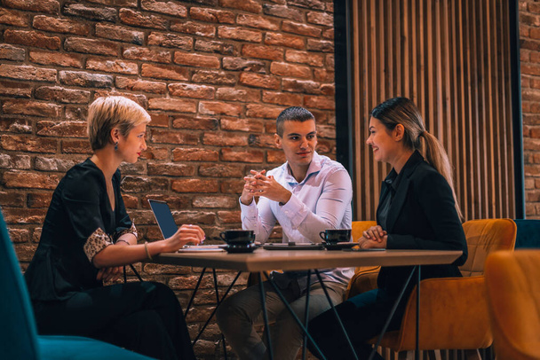Happy businessman and businesswomen having teamwork meeting for developing new strategies in a cafe. - Foto, imagen