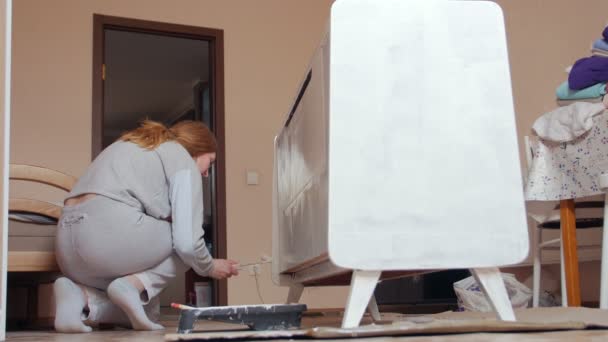 Mujer pinta muebles del gabinete - Imágenes, Vídeo