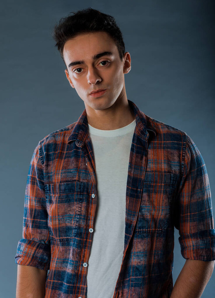 Retrato de un joven guapo con camisa a cuadros, aislado sobre fondo gris - Foto, Imagen