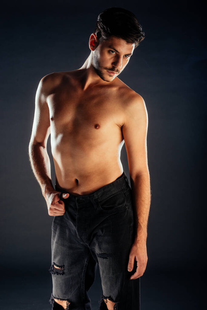Ganzkörperaufnahme eines attraktiven männlichen Models, das in moderner Kleidung posiert - Foto, Bild