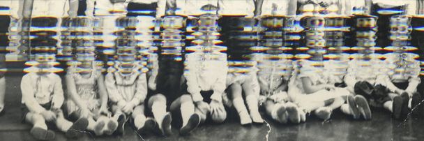 Винтажное скользящее фото группы одноклассников в классе. Ретро-фото показывает маленьких учеников в классе. Доска на заднем плане.  - Фото, изображение