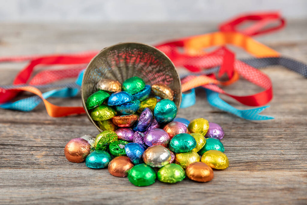 Feuille multicolore recouverte de chocolat. Feuille couvert cadeau chocolats fond en bois. Un festin de bonbons. Eid al-Fitr (Fête du Ramadan) concept. - Photo, image