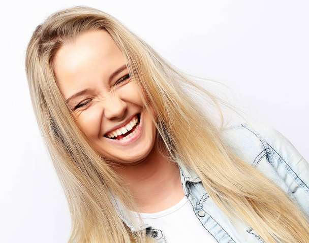 Portrait of young blonde positive female with cheerful expression, dressed in casual clothes, over white background. Beautiful woman indoor. - Foto, afbeelding