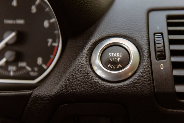 Απλό πάτημα ενός κουμπιού στην κονσόλα ταμπλό μπορεί να ξεκινήσει η ανάφλεξη του αυτοκινήτου ή να κόψει τον κινητήρα μακριά. - Φωτογραφία, εικόνα
