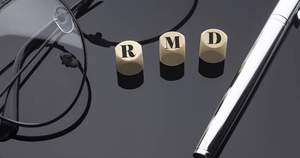 RMDの概念は、ペンとガラスと黒の背景に木製のブロック上の言葉. - 写真・画像
