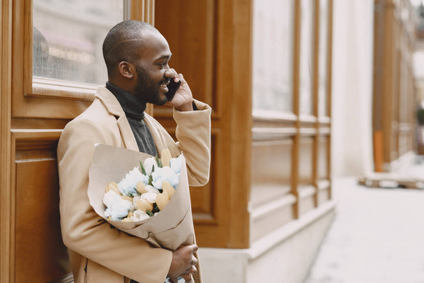 African man with bouquet of flowers waiting for girlfriend - Φωτογραφία, εικόνα