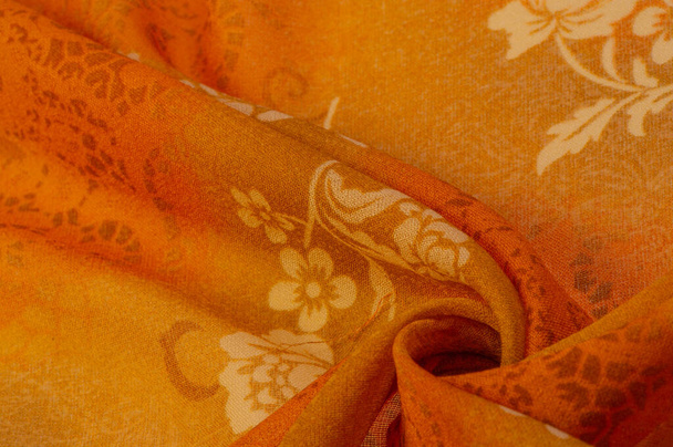 Textura, fondo, diseño, tela, seda naranja con un patrón floral. Fragmento de colorido patrón textil de seda retro con adorno floral utilizado como fondo - Foto, Imagen