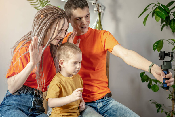 Junge moderne harmonische Familie fotografiert in heller Kleidung. Konzept von guter Laune, familiärer Betreuung und gemeinsamer Freizeitgestaltung. - Foto, Bild