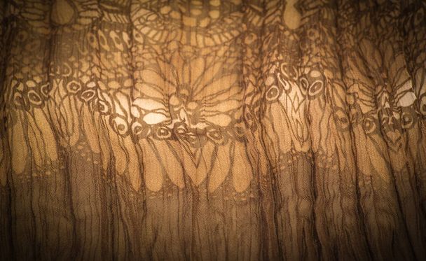 Brauner Seidenstoff, florales Muster. Welliges Wellblech. Feine Wellen auf der Oberfläche des Gewebes. Hintergrundstruktur, dekoratives Ornament - Foto, Bild