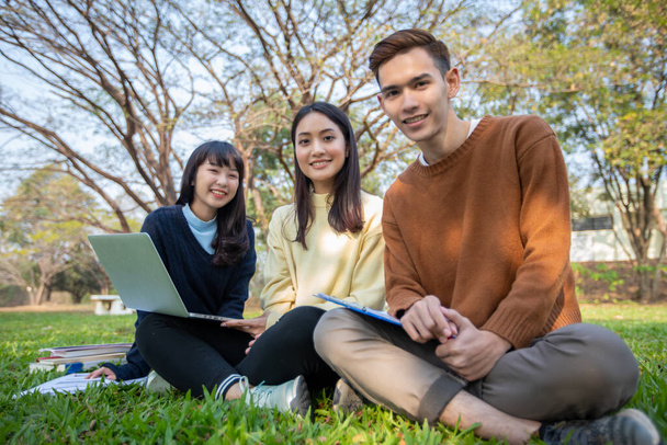 Asiatische Studenten nutzen Notebook und Tablet, um zu Hause im Garten zu arbeiten und online zu lernen - Foto, Bild