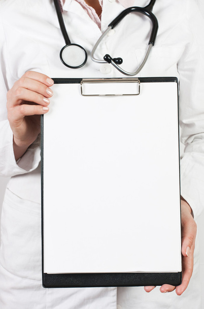 Closeup of female medical doctor holding blank clipboard. - Photo, Image