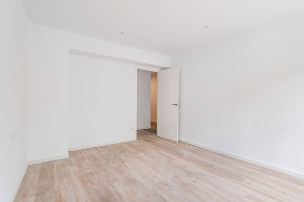 Lege witte kamer na renovatie met stoffige houten vloer - Foto, afbeelding
