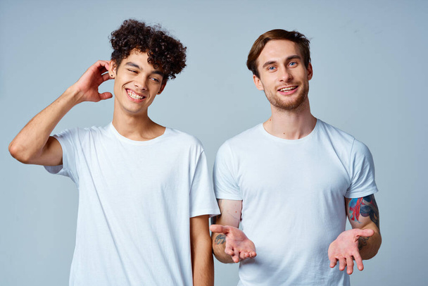 Emotionale zwei Freunde in weißen T-Shirts ja lustiges Studio - Foto, Bild