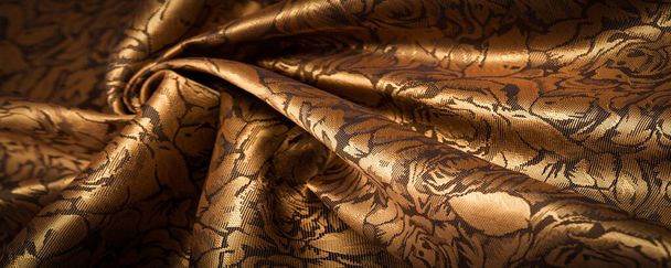 silk fabric with flower pattern, dark yellow, golden color, unique shine, embossed pattern, composite textile. relief pattern - Photo, Image