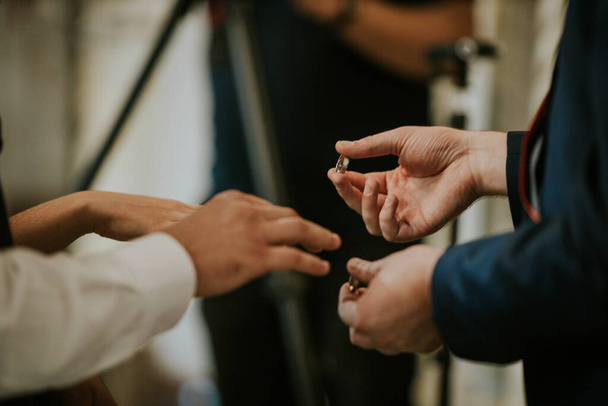 A shallow focus of a groom putting the ring on a bride's finger during the wedding celebration - Valokuva, kuva
