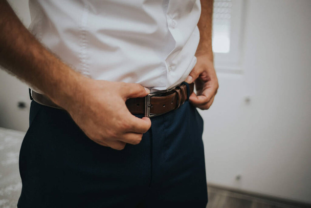 A closeup of a man fixing his belt - Fotografie, Obrázek