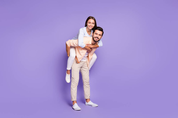 Full length photo of man and woman piggyback ride free time weekend carefree isolated on violet color background - Foto, Imagen