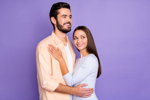 Photo of cheerful married couple look empty space hug harmony dream happy life isolated on purple color background - Zdjęcie, obraz