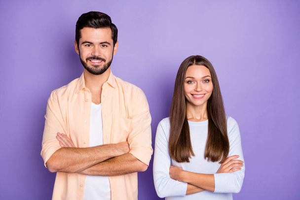 Photo of happy joyful man and woman folded hands cheerful smile good mood isolated on violet color background - Фото, изображение