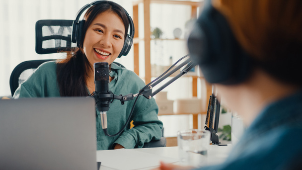 Asia girl radio host record podcast gebruik microfoon dragen koptelefoon interview beroemdheid gast inhoud gesprek praten en luisteren in haar kamer. Audio podcast van thuis, Sound equipment concept. - Foto, afbeelding