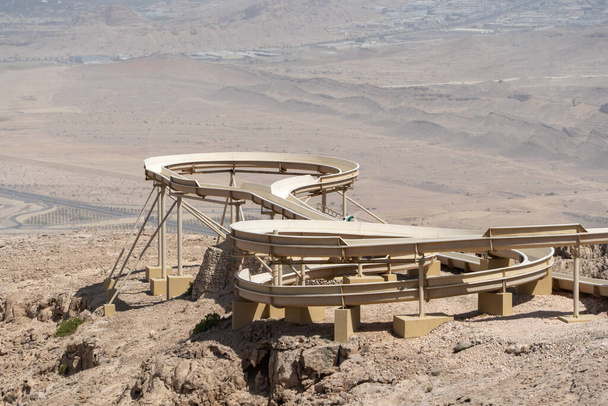Відновлювальний слайд з видом на місто Аль-Айн в Об'єднаних Арабських Еміратах нижче. Вершина Джевал - Хафіс.. - Фото, зображення