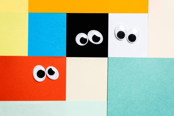 Smileys from toy eyes on hermetic multi-colored background - Photo, Image