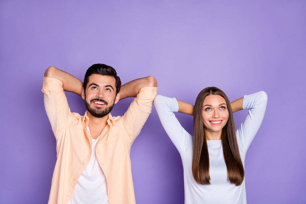 Photo of positive pretty lady handsome guy arms behind head look up empty space isolated on violet color background - Φωτογραφία, εικόνα