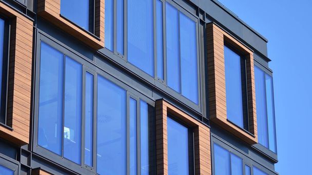 Ofis binasının çelik ve cam metal cephesinin bir parçası. Açık mavi gökyüzü arka planında çelik ve cam cephe mimarisini detaylandır. Modern mimari yapı cephesi. - Fotoğraf, Görsel