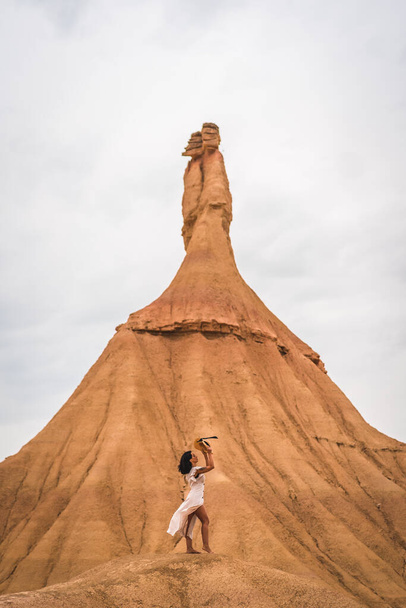 Young brunette Caucasian girl with a white dress and a straw hat in the Castildetierra of the Bardenas Reales desert, Navarra. Spain - Foto, imagen