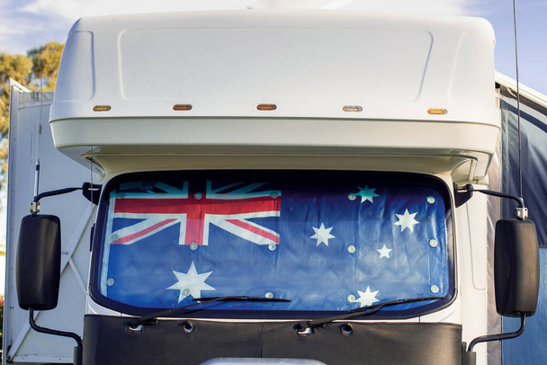 Motorhome campervan with flag of Australia on the windscreen at the campground. Australian camping, tourism and travel lifestyle concept - Photo, Image