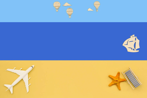Plane, sailboat, air balloons and sun lounger on a colored background top view. Travel background for travel agency, poster. Flat lay view. - Photo, Image