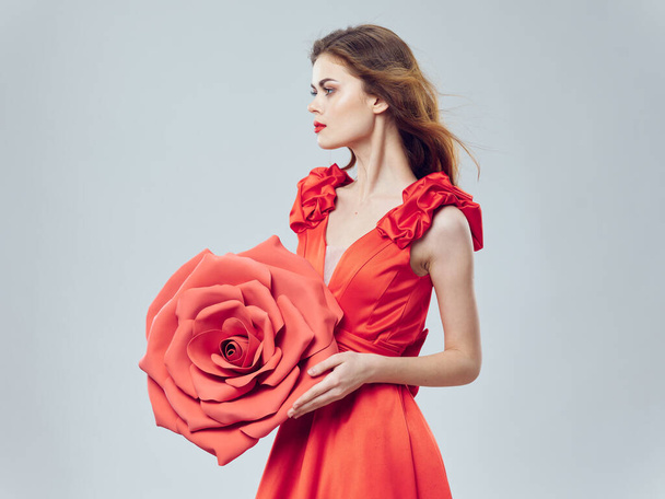 woman in red dress with decorative flower on light background cropped view - Photo, Image