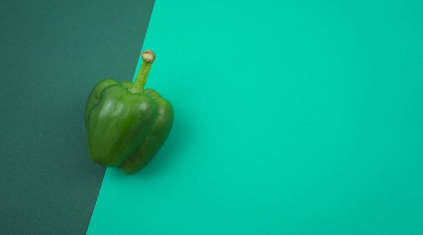 Φρέσκο πράσινο γλυκό ή bell pepper επίπεδη θέσει σε τυρκουάζ πράσινο φόντο υφή. Ελεύθερος χώρος για το σχεδιασμό σας, κορυφαία άποψη, οριζόντια, χωρίς στυλ εικόνας ανθρώπων. - Φωτογραφία, εικόνα