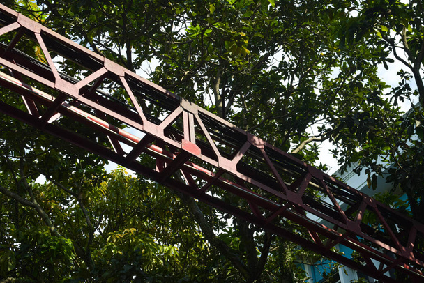 マラン市内の建物の木の下の道路上の電線を支える橋 - 写真・画像