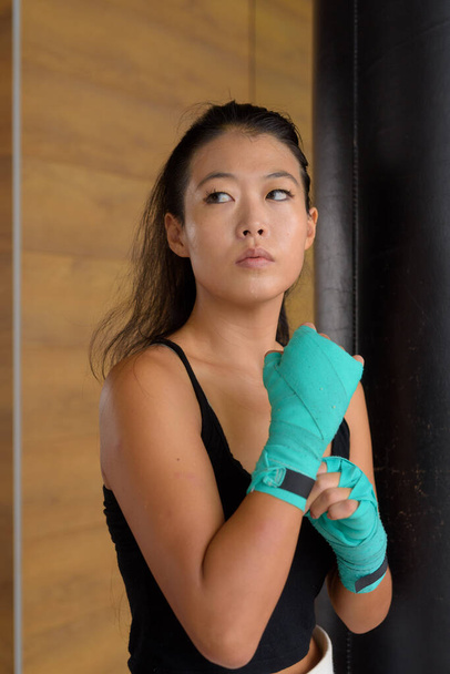 Красивая молодая азиатка-боксер готова к тренировкам в спортзале - Фото, изображение