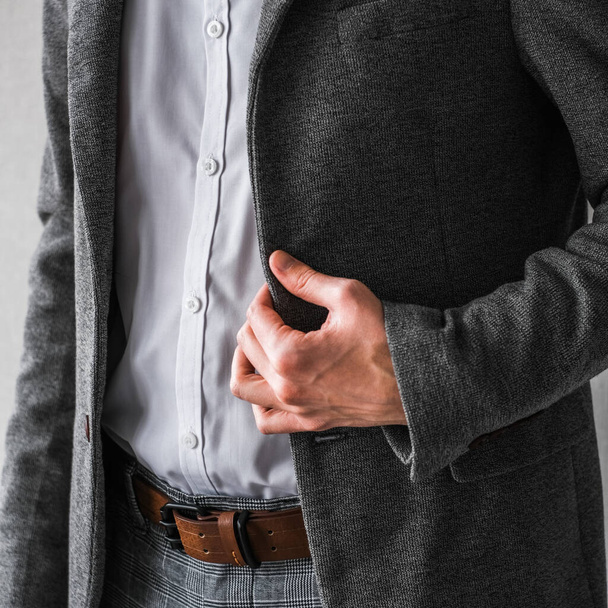 un hombre con una chaqueta gris clásica y una camisa blanca sobre un fondo claro. Un hombre de negocios con traje. maqueta - Foto, Imagen