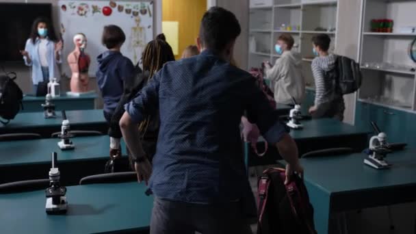 Maszkos, többnemzetiségű diákok hagyják el az osztálytermet - Felvétel, videó