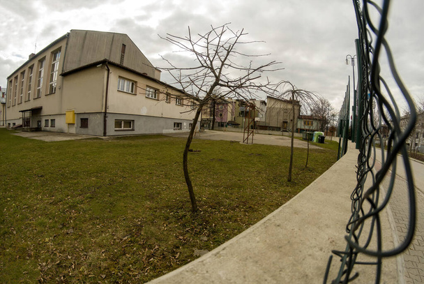 Широкий кут огляду через проламані проводи паркану в Банч шкільних приміщень, розташованих в південному польському місті. Польща, Європа - Фото, зображення